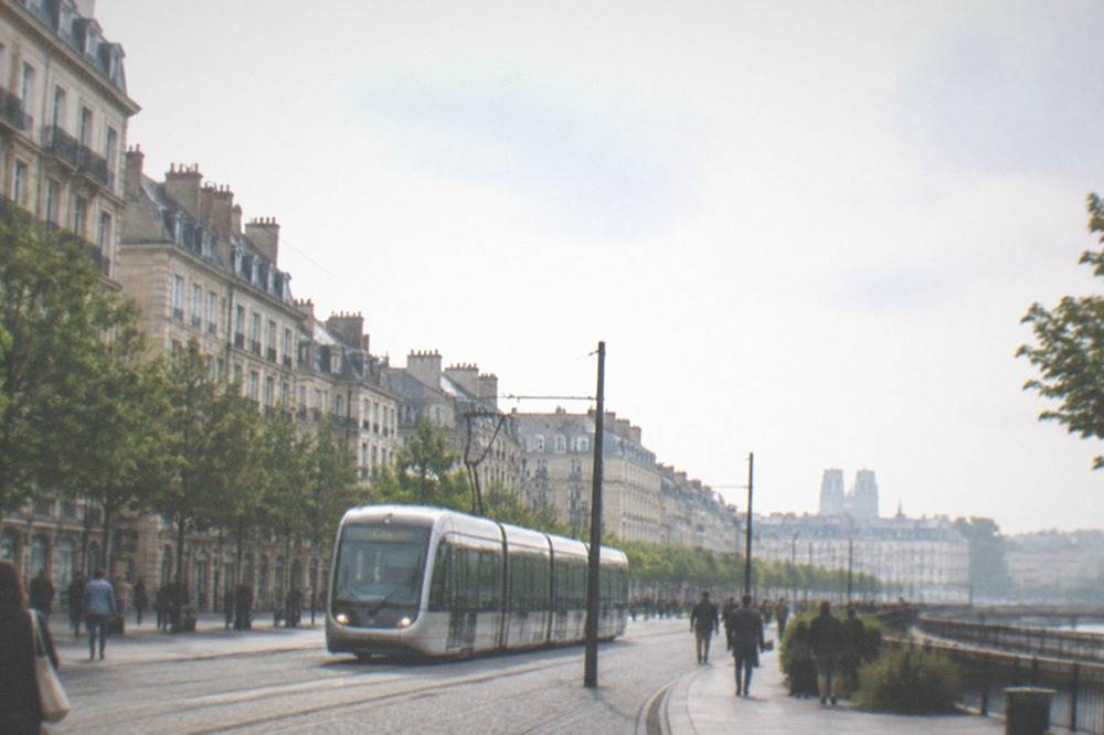 A Nantes tram passing through a city centre street with pedestrians