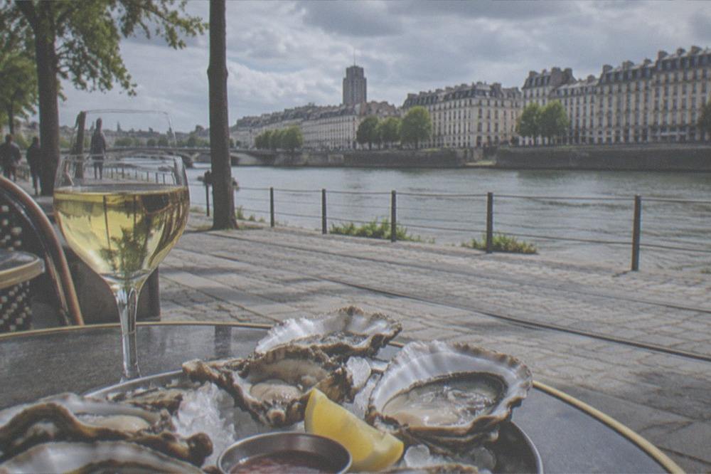 Fresh oysters and a glass of white wine on a café table in Nantes