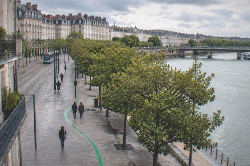 The green painted line of the Voyage à Nantes trail on a city pavement