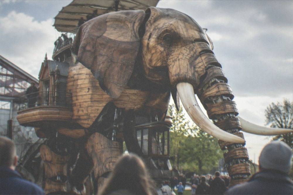 Mechanical elephant of the Machines de l'ile walking past visitors