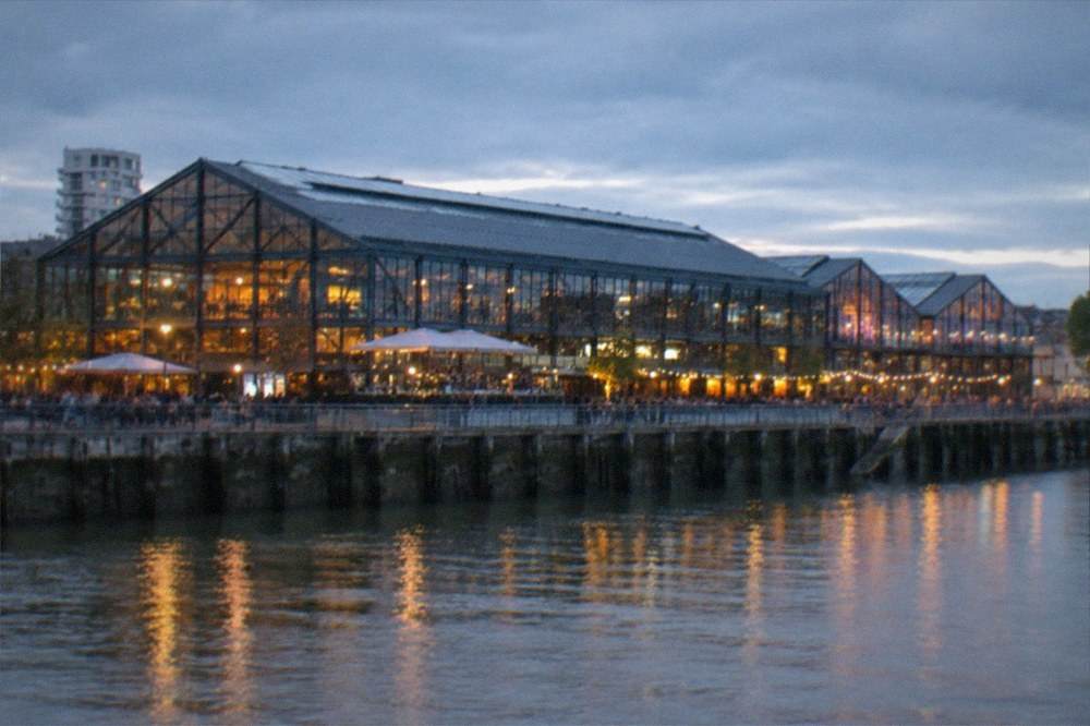 Riverside bars lit up along the Hangar a Bananes in the evening