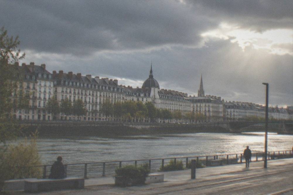 Dark storm clouds passing over the Loire river in Nantes with sunlight breaking through