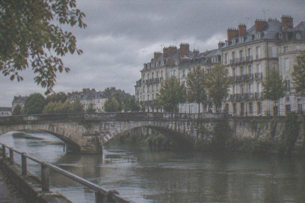 A small stone bridge over a calm river in a countryside village near Nantes