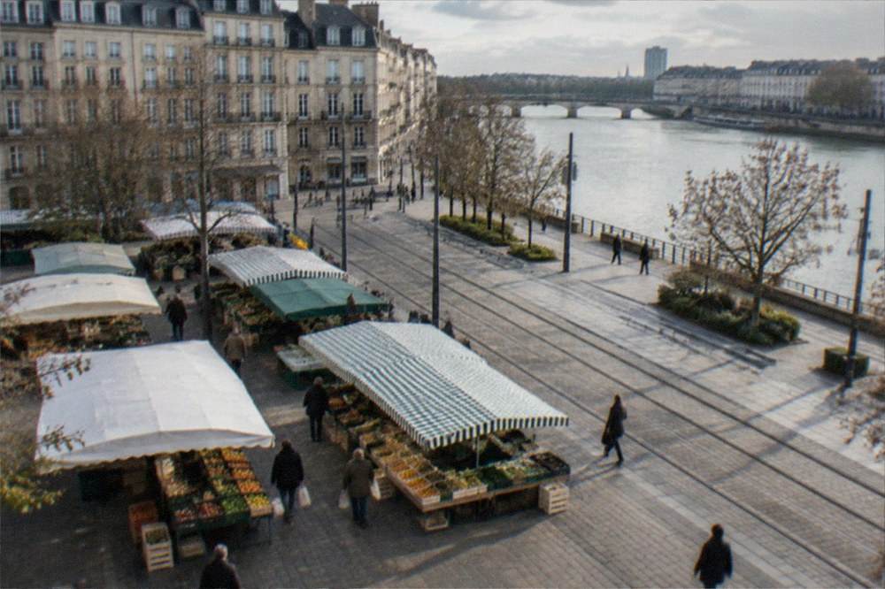 An outdoor food market stall with fresh produce under awnings in Nantes