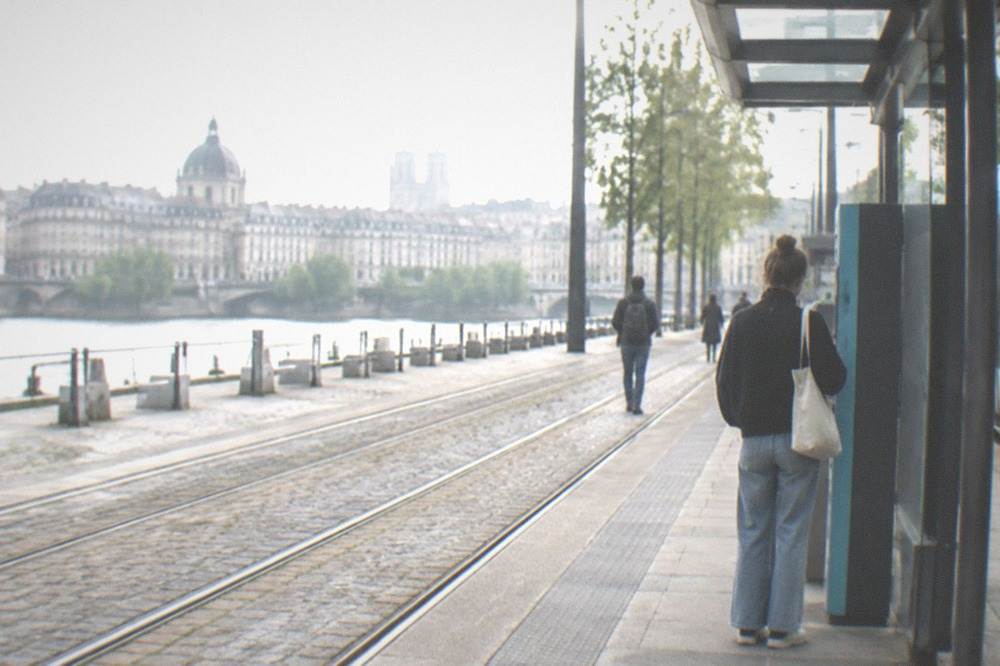 A Naolib ticket machine at a Nantes tram stop with a passenger buying a ticket