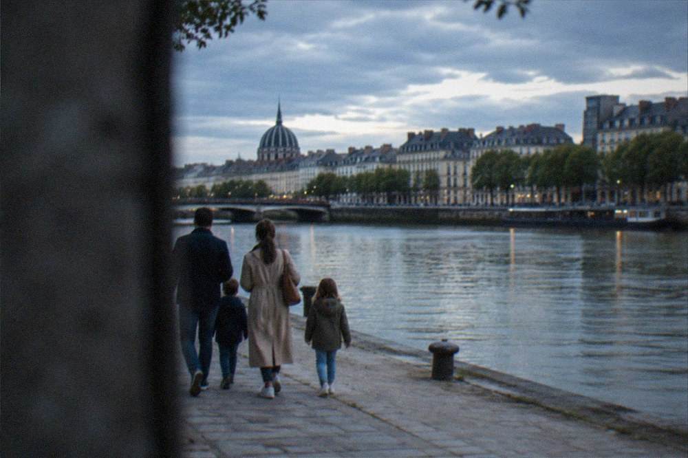 A family with two children walking along a riverside quay in Nantes