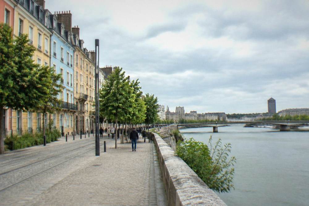 Colourful painted house facades along a riverside street in a Nantes neighbourhood