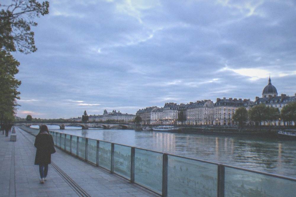 A riverside memorial walkway with engraved glass panels along the Loire in Nantes