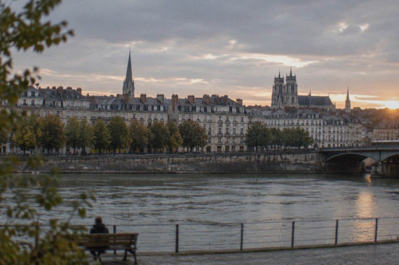 Rooftops and church spires of central Nantes seen across the Loire at dusk