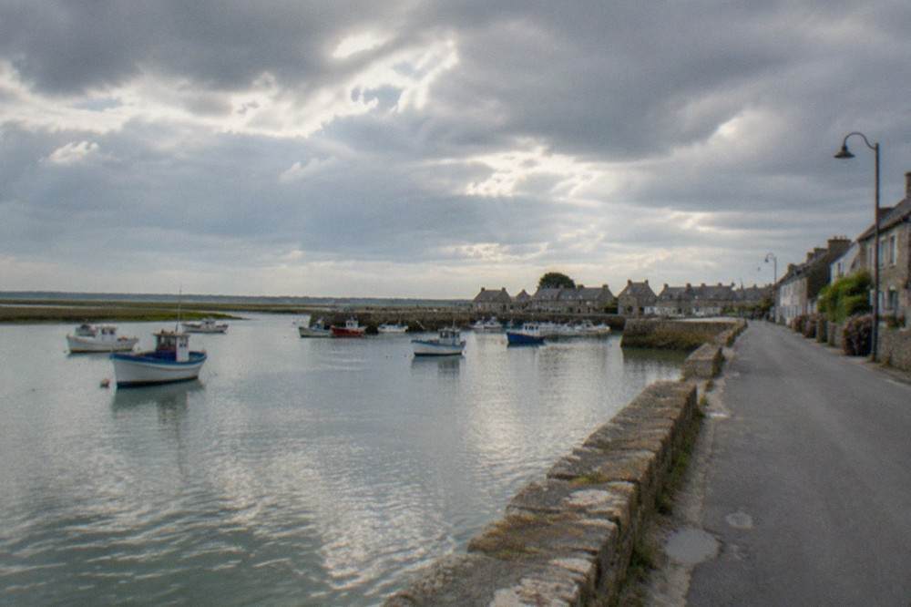 A quiet coastal road running beside calm Atlantic water near Le Croisic in Brittany