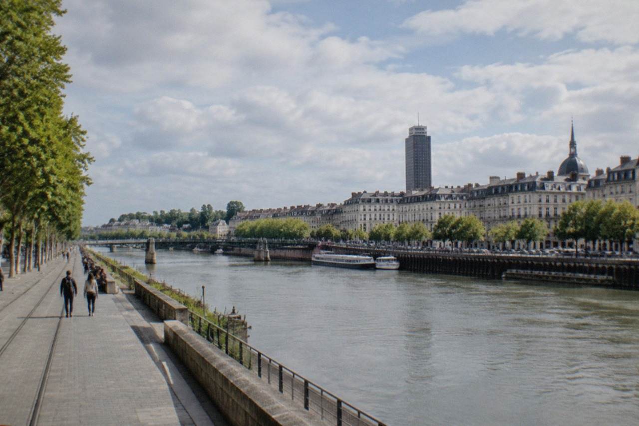 The Loire river flowing past the towers and quays of Nantes on a bright morning