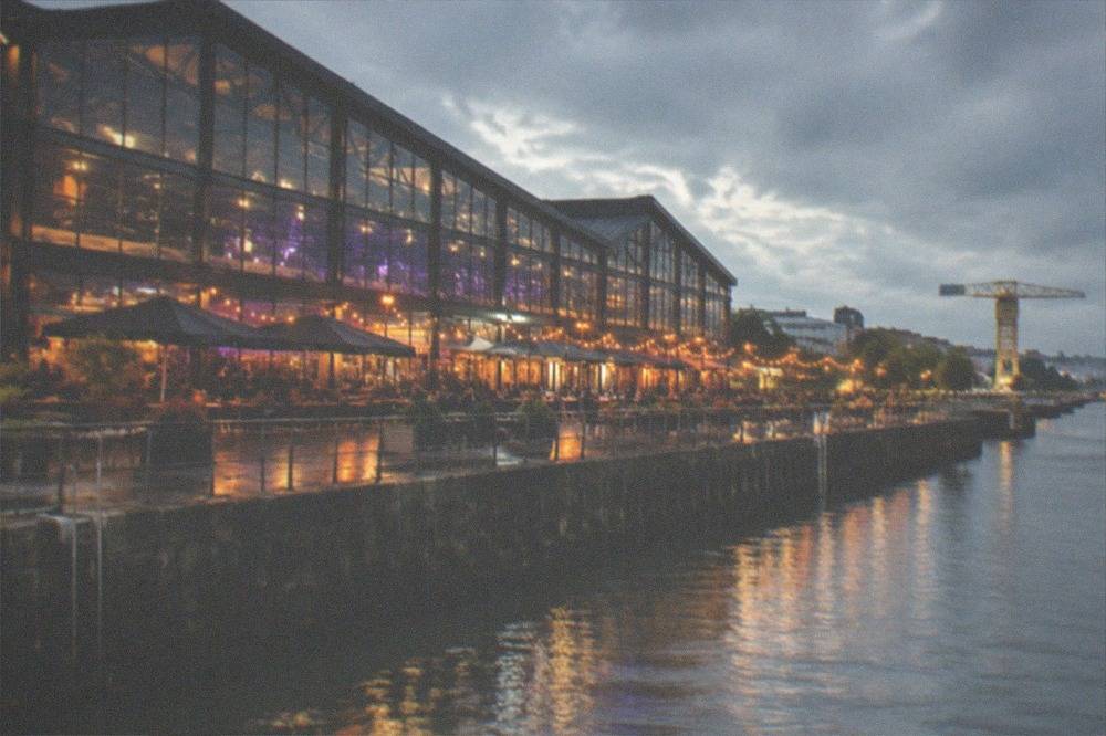 The floodlit Hangar à Bananes warehouse bars along the Loire riverfront on the Île de Nantes at night