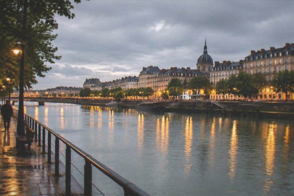 The lit quays of the Loire in Nantes at night with reflections of lamps on the river surface