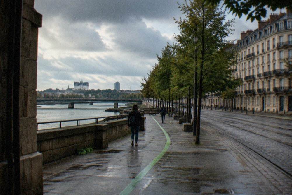 A green painted trail line on a Nantes pavement leading past historic stone buildings
