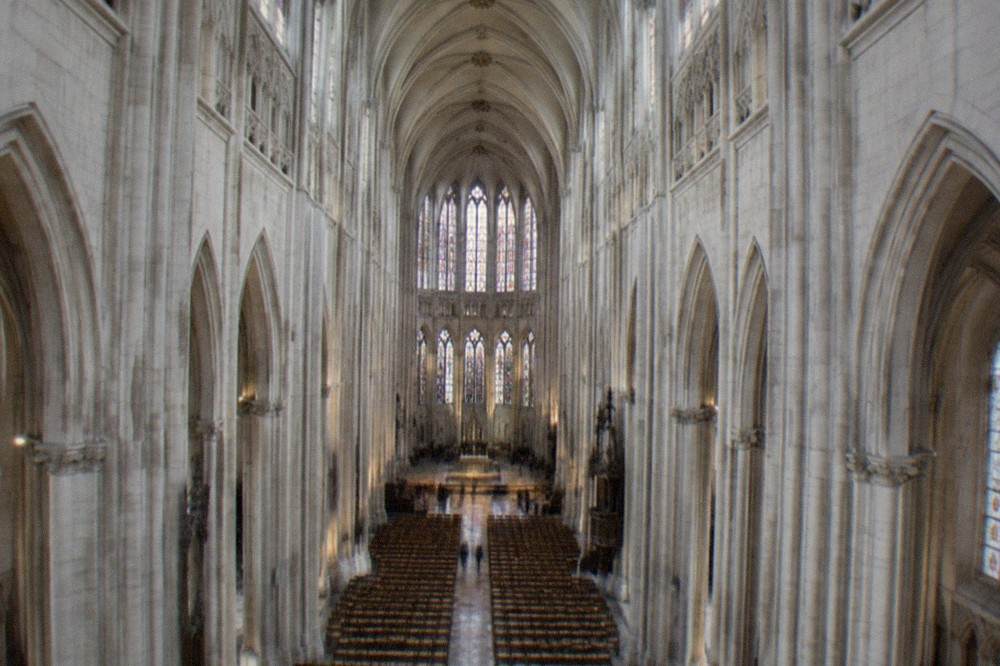 The nave of Nantes cathedral seen from the west end, with restored stonework and high gothic vaults