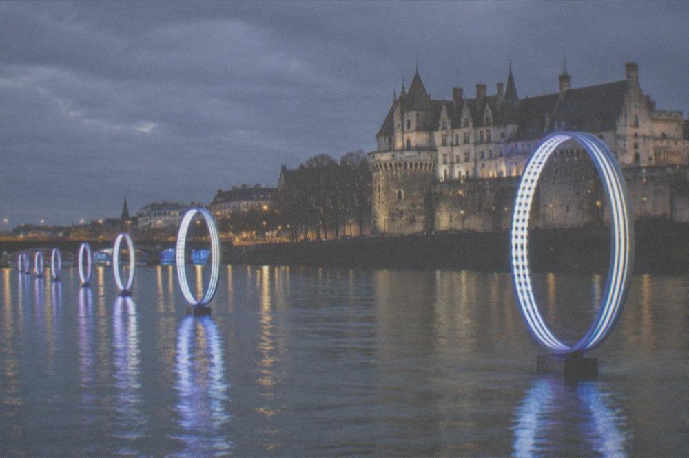 The illuminated Buren rings standing in the Loire at night, seen from the quai des Antilles