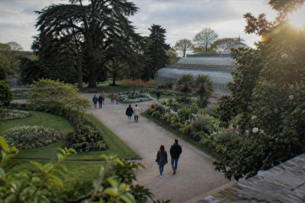People strolling beside flowerbeds on a wide path in the Jardin des Plantes in Nantes