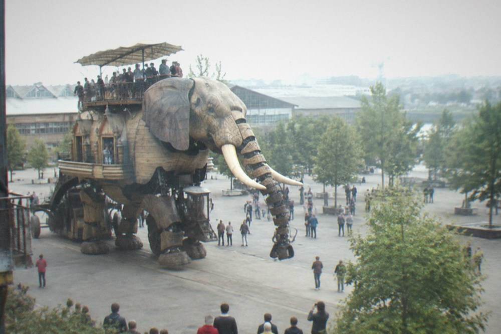 The mechanical elephant of Les Machines de l'île walking past visitors on the Île de Nantes