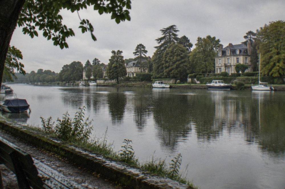 Waterside trees reflected in the calm surface of the Erdre river