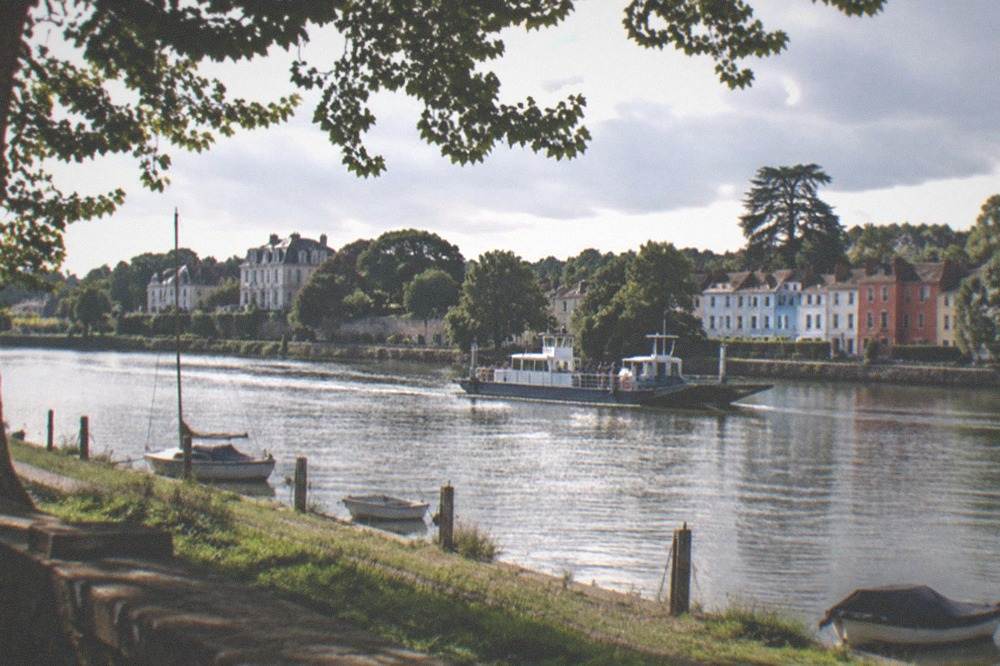 A ferry crossing the Loire toward Trentemoult with coloured house fronts behind