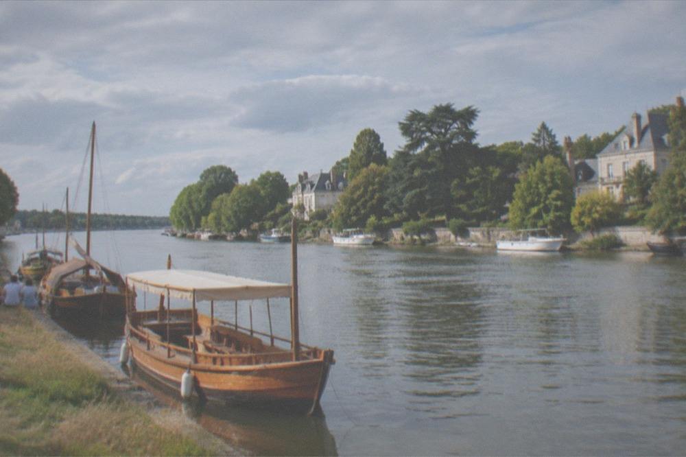 Wooden heritage boats moored along the Erdre during a summer festival