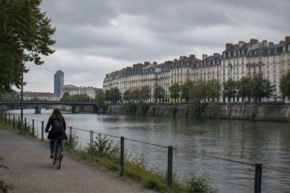 A cyclist following a riverside path beside the Erdre in Nantes